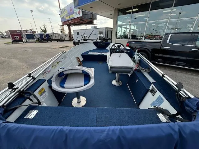 Slide: The Image of 1990 Smoker Craft Resorter boat interior with blue seating and steering wheel. - 16