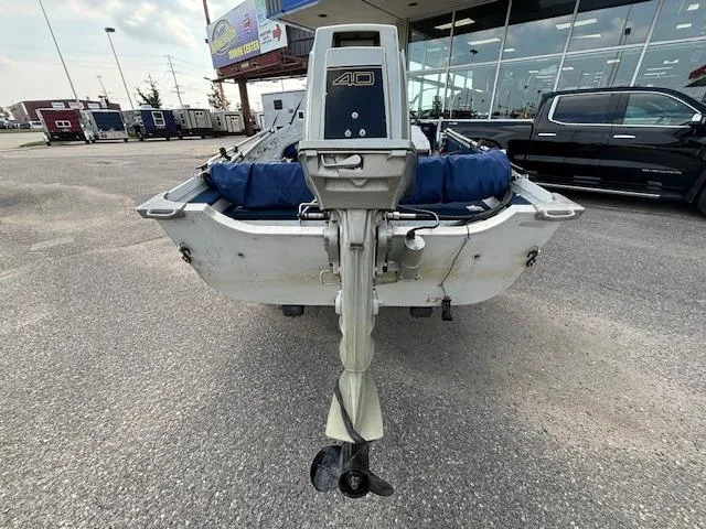 Slide: The Image of 1990 Smoker Craft Resorter boat with 40 HP outboard motor, parked outdoors. - 18