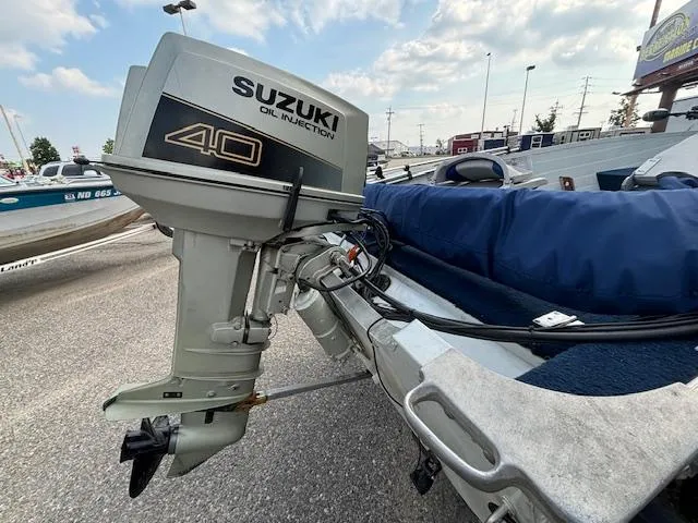 Slide: The Image of 1990 Smoker Craft Resorter with Suzuki 40 outboard motor, parked on a trailer. - 19