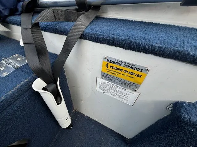 Slide: The Image of 1990 Smoker Craft Resorter boat interior with capacity label and safety equipment. - 2