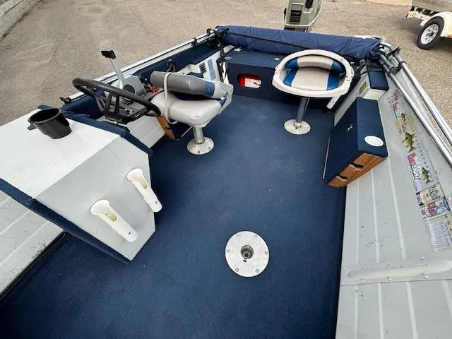 Slide: The Image of 1990 Smoker Craft Resorter boat interior with blue carpet and seating. - 5