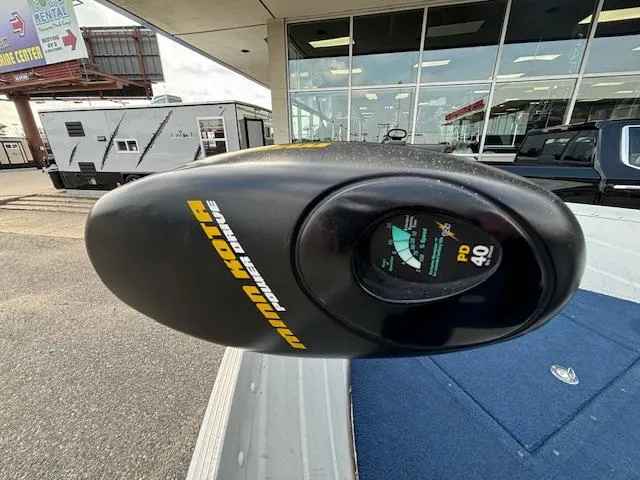 Slide: The Image of Minn Kota trolling motor on 1990 Smoker Craft Resorter boat, parked near dealership. - 6