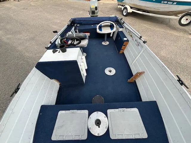 Slide: The Image of 1990 Smoker Craft Resorter boat interior with blue carpet and steering wheel. - 7
