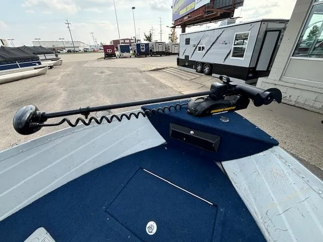Slide: The Image of 1990 Smoker Craft Resorter boat with trolling motor in a marina setting. - 8