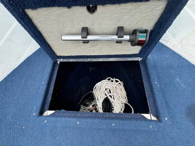 Slide: The Image of 1990 Smoker Craft Resorter boat storage compartment with rope and anchor. - 9
