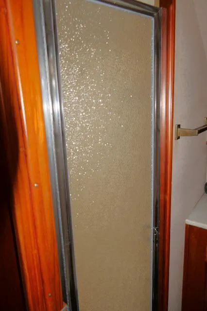 Slide: The Image of 1988 Jersey 36 Convertible Sportfisher cabin with striped bedding and wooden interior. - 17