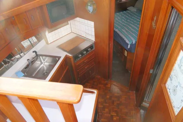 Slide: The Image of Interior of 1988 Jersey 36 Convertible Sportfisher with wooden table and blue sofa. - 6