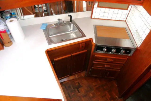 Slide: The Image of 1988 Jersey 36 Convertible Sportfisher interior with gray sofa, wooden table, and striped carpet. - 8