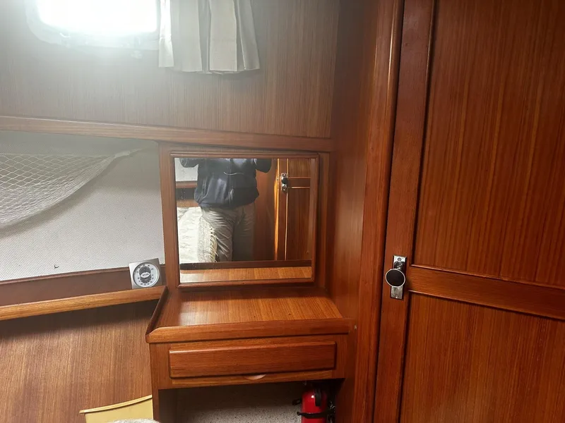 Slide: The Image of 1982 CHB Oceans interior with wooden cabinetry, mirror, and small desk area. - 11