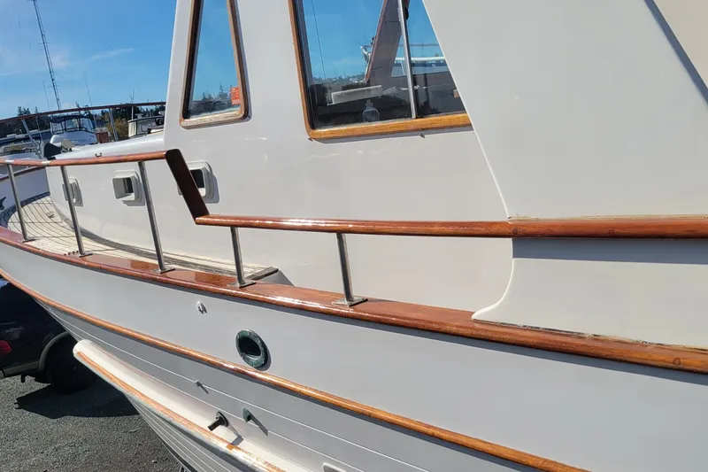 Slide: The Image of 1982 CHB Oceans boat with polished wood railings and white exterior. - 15