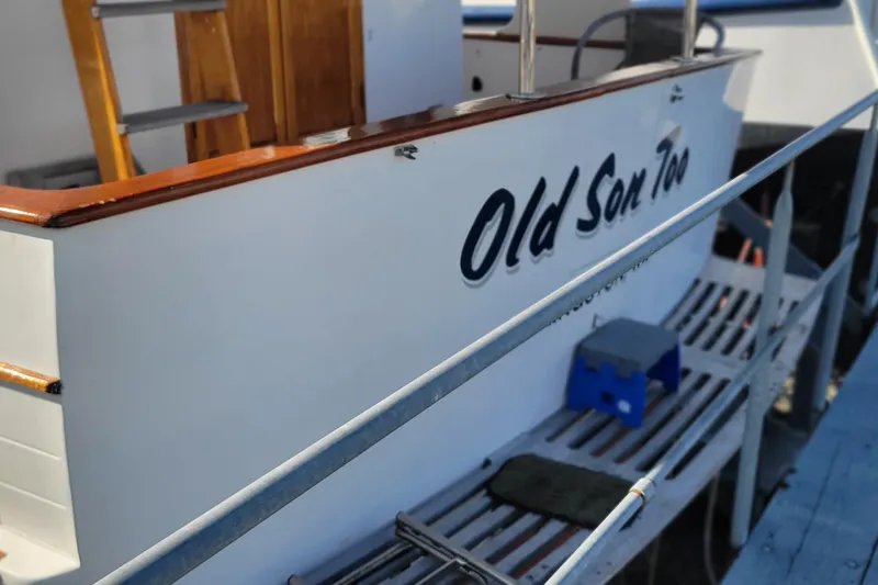 Slide: The Image of 1982 CHB Oceans boat named "Old Son Too" with wooden ladder and deck. - 16
