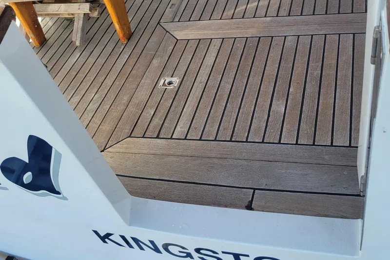 Slide: The Image of Wooden deck of 1982 CHB Oceans boat, featuring sleek design and visible name "KINGSTO". - 20