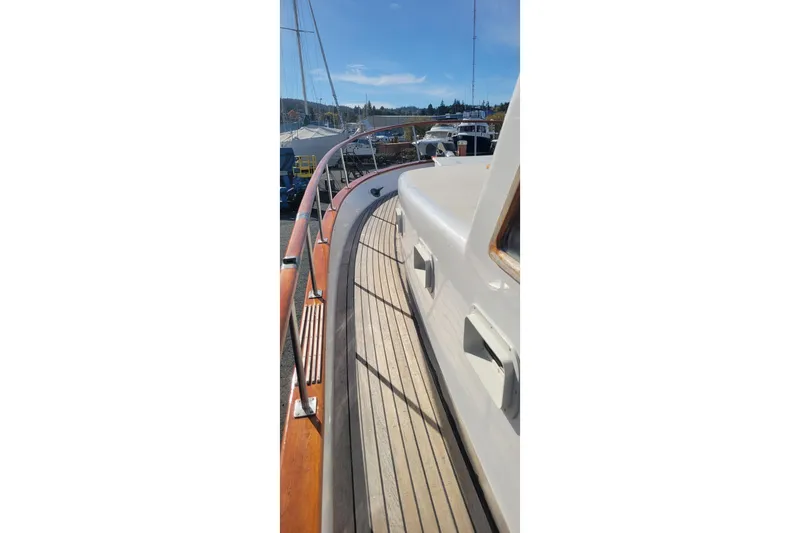 Slide: The Image of 1982 CHB Oceans yacht deck with wooden railings and scenic marina view. - 22