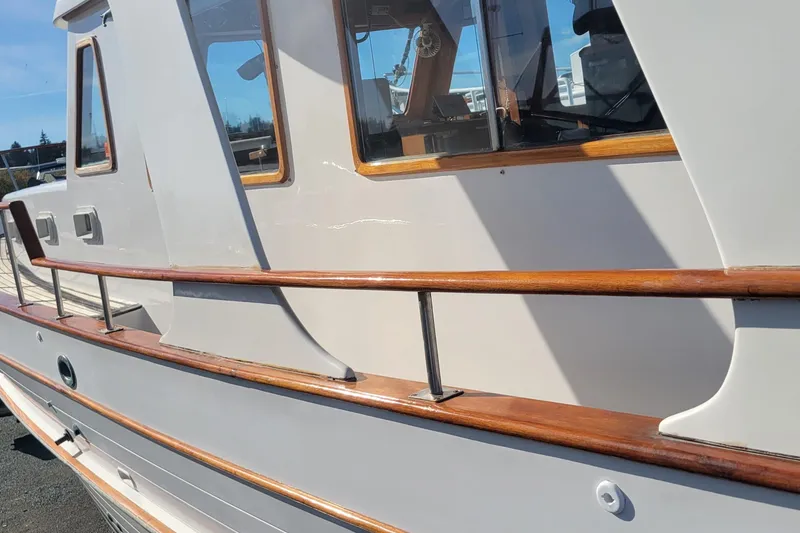 Slide: The Image of 1982 CHB Oceans boat with wooden railings and windows, docked under clear skies. - 24