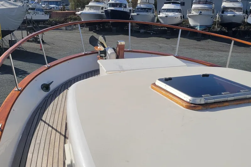 Slide: The Image of 1982 CHB Oceans yacht deck with wooden railings and hatch, surrounded by docked boats. - 25