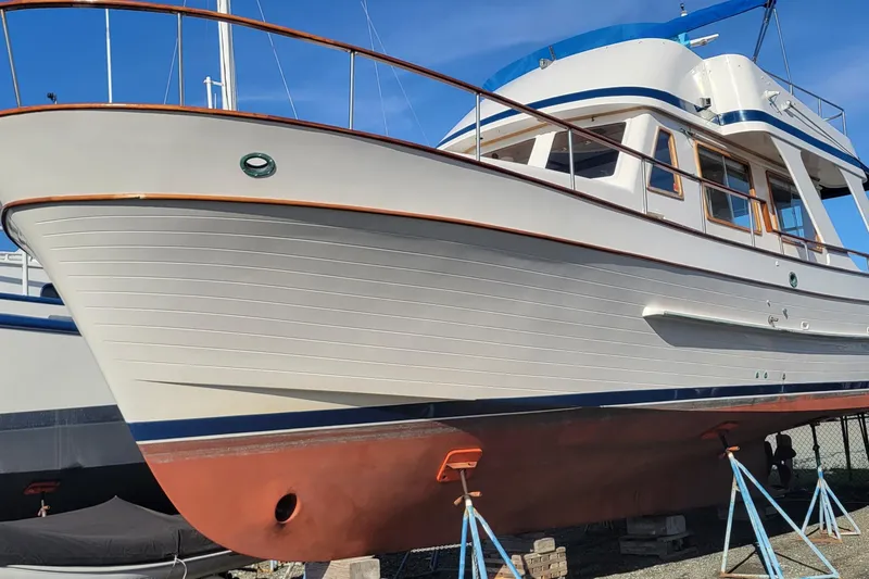 Slide: The Image of 1982 CHB Oceans boat on stands, showcasing classic design and wooden accents. - 26