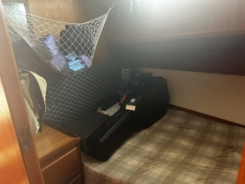 Slide: The Image of Cozy cabin interior of 1982 CHB Oceans boat with net storage and plaid bedding. - 3