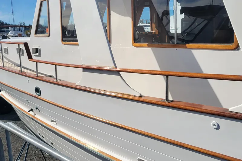 Slide: The Image of 1982 CHB Oceans boat with wooden railings and windows, docked under clear skies. - 30