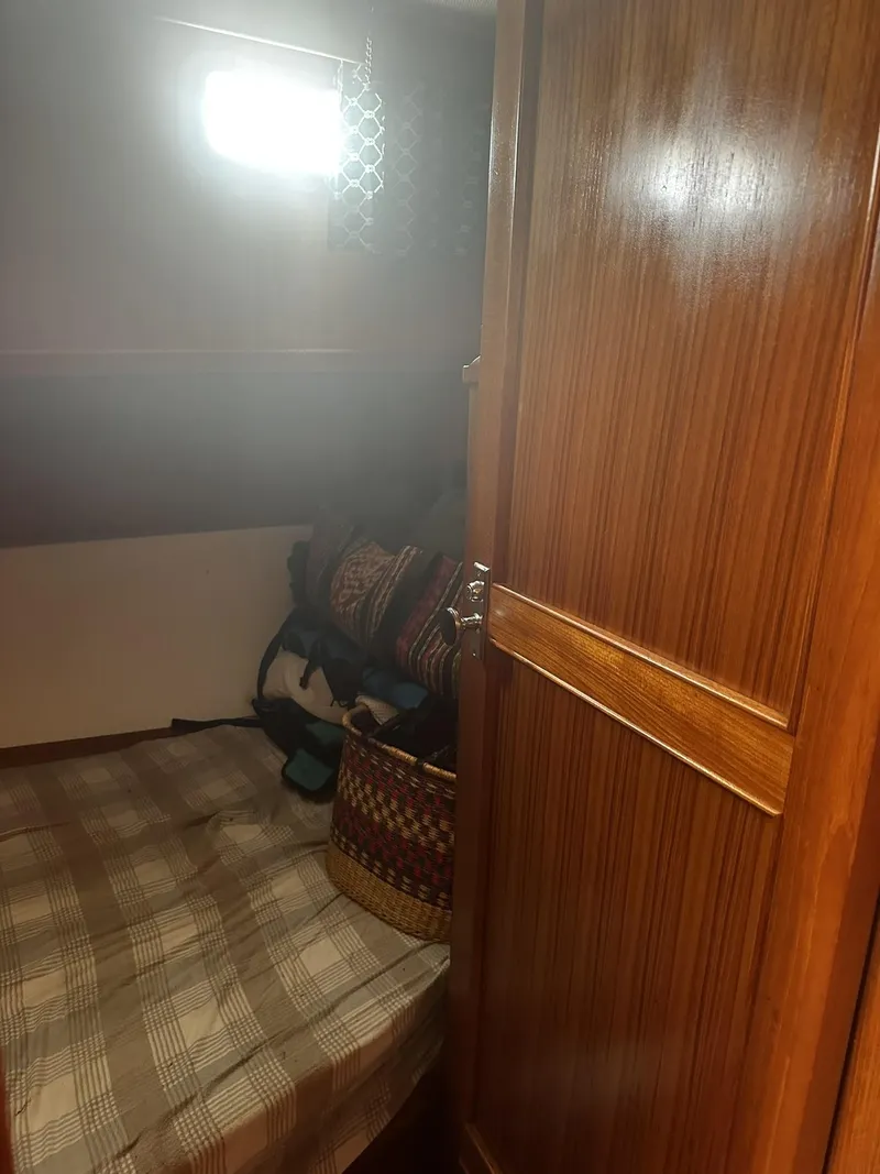 Slide: The Image of 1982 CHB Oceans cabin interior with wooden door, bed, and storage space. - 4