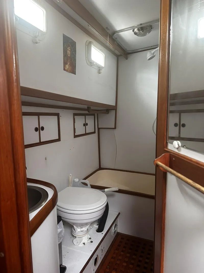 Slide: The Image of 1982 CHB Oceans boat bathroom with wooden accents, white fixtures, and natural light. - 5