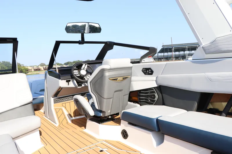 Slide: The Image of Interior of 2025 Nautique G25 boat with modern seating and steering wheel. - 11