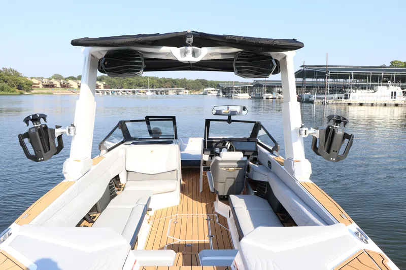 Slide: The Image of 2025 Nautique G25 boat interior with sleek seating and advanced audio system on a serene lake. - 13