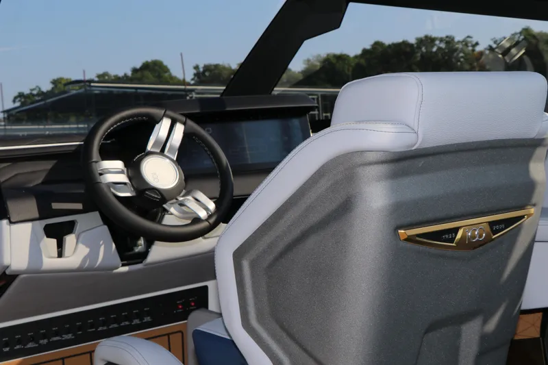 Slide: The Image of Interior of 2025 Nautique G25 boat, featuring modern steering wheel and dashboard. - 19