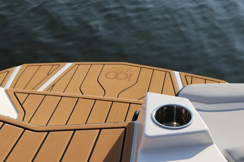 Slide: The Image of 2025 Nautique G25 boat deck with cup holder, wood finish, on water. - 21