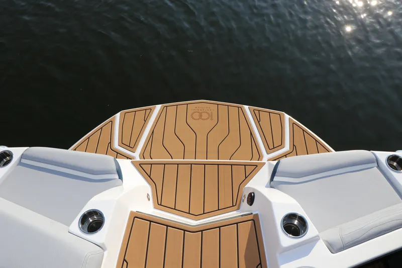 Slide: The Image of 2025 Nautique G25 boat deck with teak flooring on water. - 22