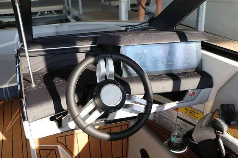 Slide: The Image of 2025 Nautique G25 boat dashboard with modern steering wheel and digital display. - 24