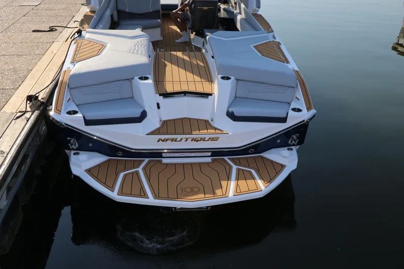 Slide: The Image of 2025 Nautique G25 boat docked, featuring sleek design and spacious seating. - 8