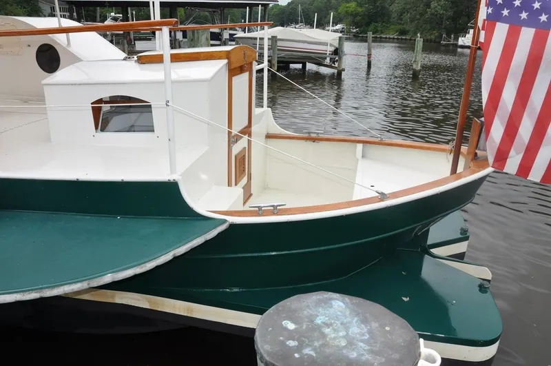 Slide: The Image of Custom 1987 sidewheel paddle yacht docked, featuring green and white design with American flag. - 11