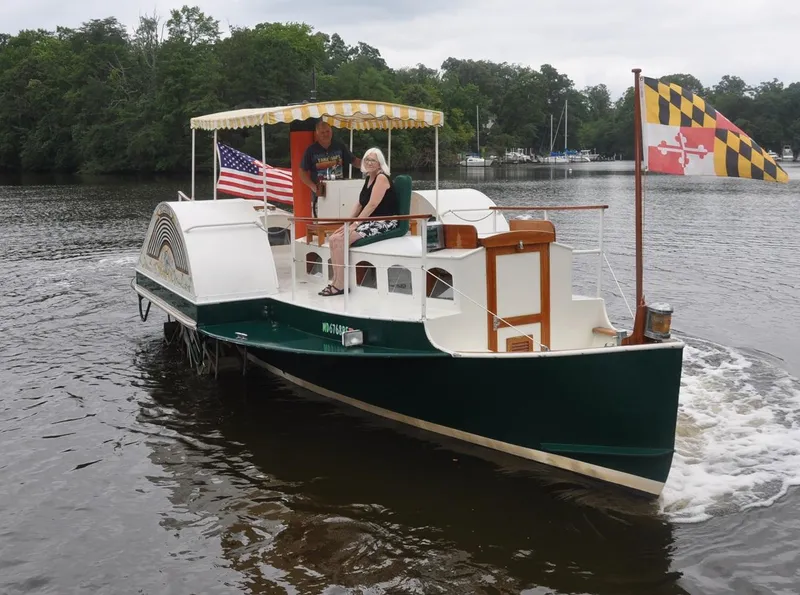 Slide: The Image of Custom 1987 sidewheel paddle yacht on a river, featuring American and Maryland flags. - 2