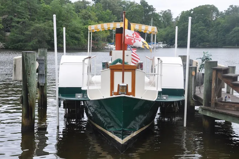 Slide: The Image of Custom 1987 sidewheel paddle yacht docked on a serene river with lush greenery. - 7