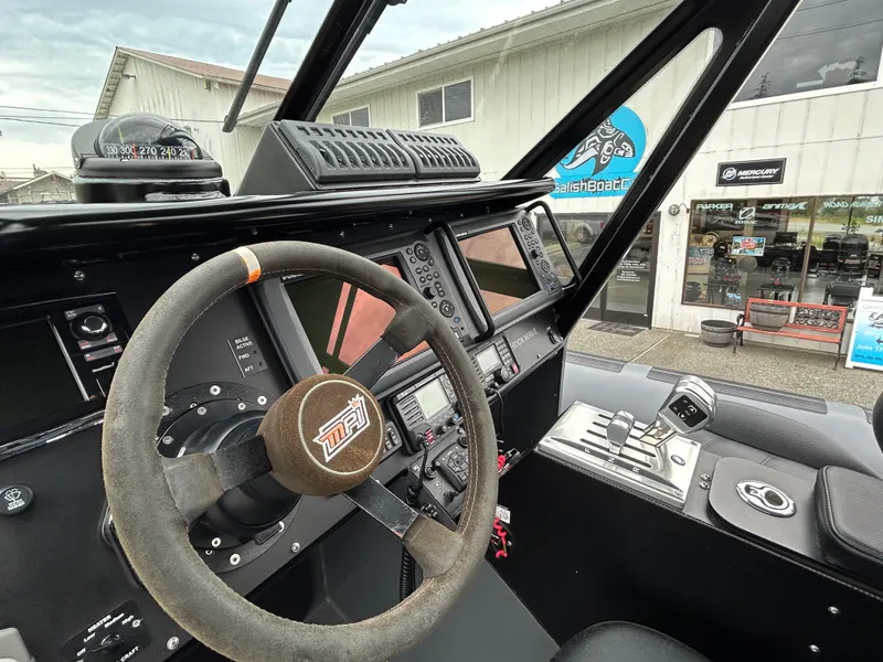 Slide: The Image of Steering wheel and dashboard of a 2015 Titan 33 boat, outside a marine shop. - 9