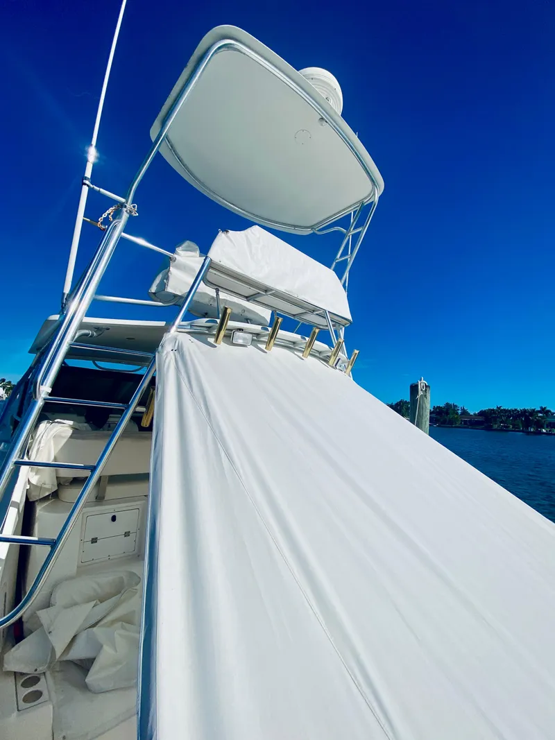 Slide: The Image of 1999 Tiara Yachts 43 Open with white cover, docked under clear blue sky. - 27