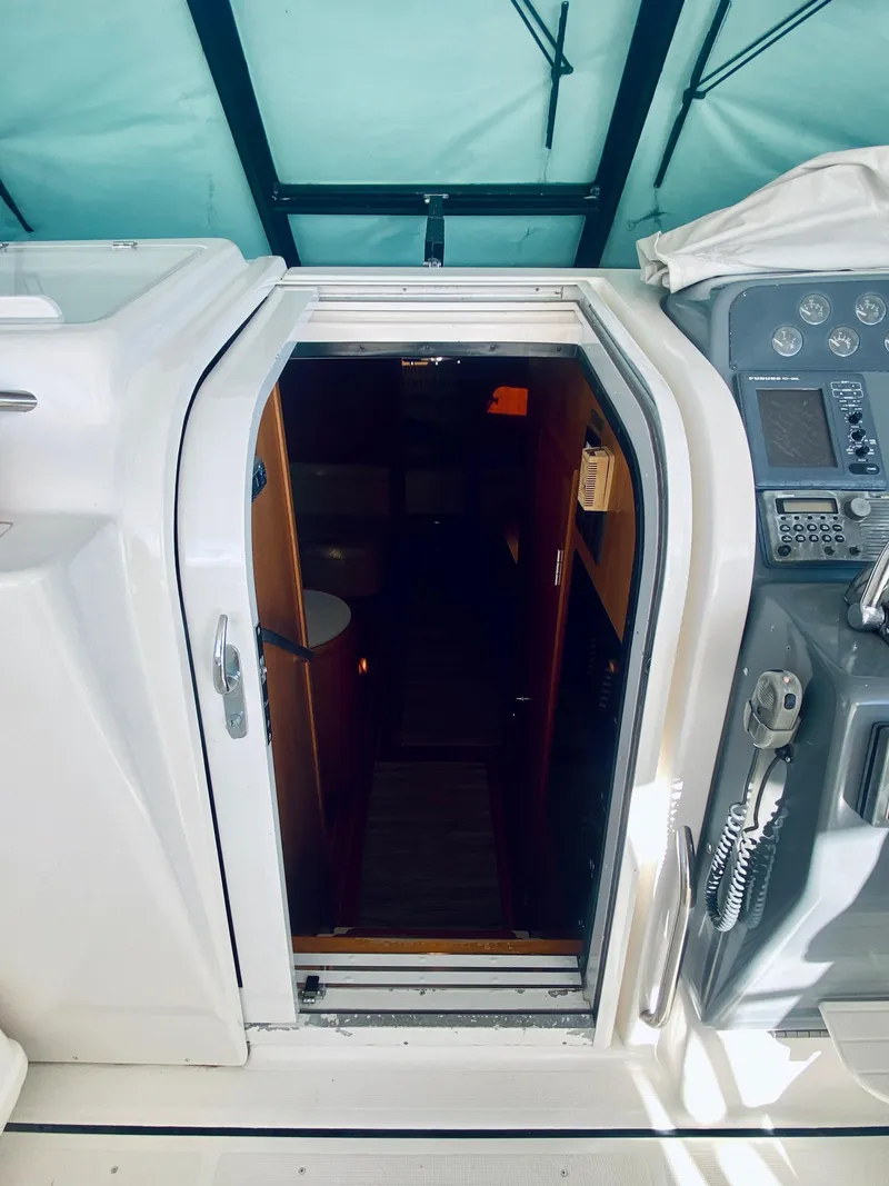 Slide: The Image of 1999 Tiara Yachts 43 Open cabin entrance with control panel and seating area. - 43