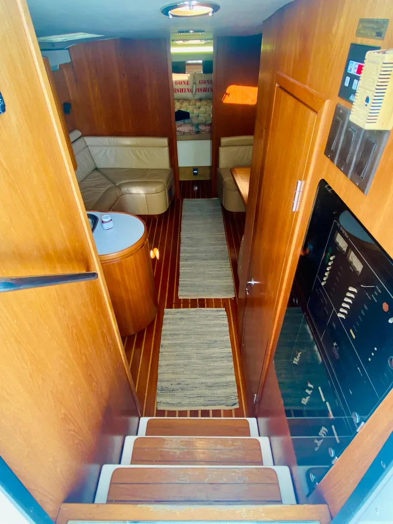Slide: The Image of Interior of 1999 Tiara Yachts 43 Open, featuring wood paneling and cozy seating. - 44