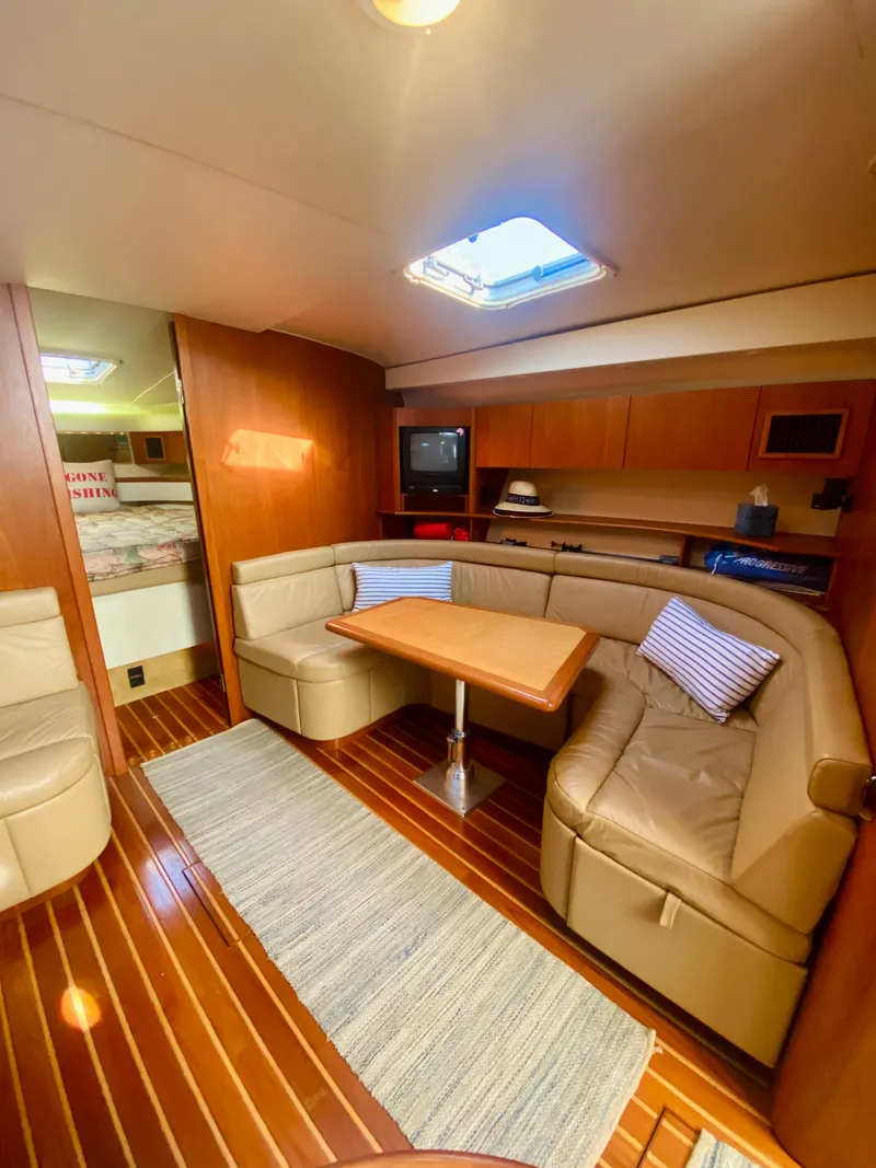 Slide: The Image of 1999 Tiara Yachts 43 Open interior with cozy seating and wooden flooring. - 49