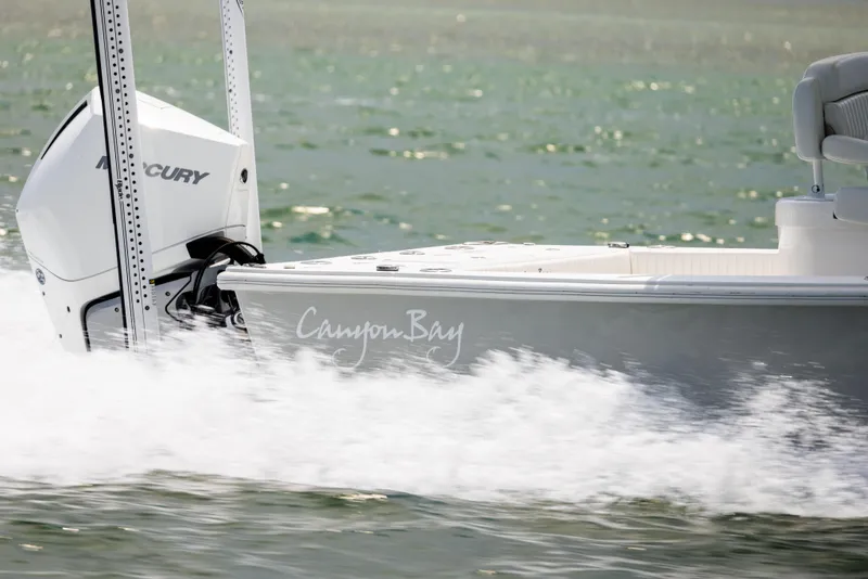 Slide: The Image of 2023 Canyon Bay 28h boat cruising on water with Mercury engine. - 10
