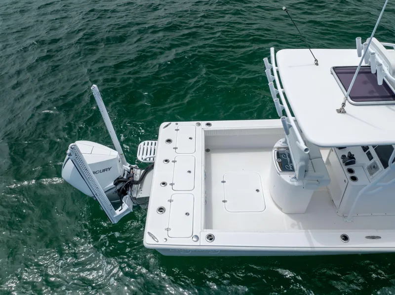 Slide: The Image of Canyon Bay 28h 2023 boat on water, featuring spacious deck and powerful outboard motor. - 19