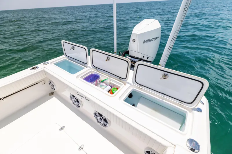 Slide: The Image of Canyon Bay 28h boat with open storage compartments, 2023 model, on the ocean. - 28