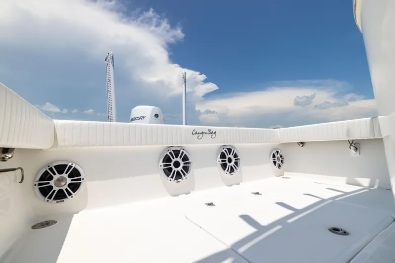 Slide: The Image of 2023 Canyon Bay 28h boat deck with speakers under a clear blue sky. - 29