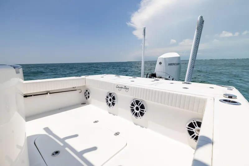 Slide: The Image of 2023 Canyon Bay 28h boat on open water, featuring spacious deck and Mercury engine. - 31