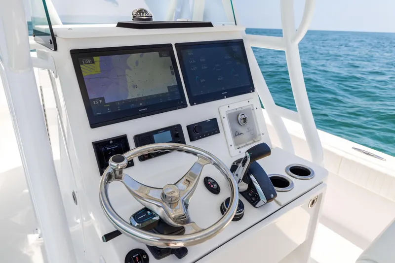 Slide: The Image of Canyon Bay 28h 2023 boat dashboard with navigation screens and steering wheel. - 46