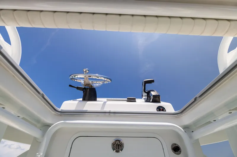 Slide: The Image of Canyon Bay 28h boat helm view against clear blue sky, 2023 model. - 47