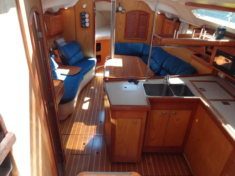 Slide: The Image of Interior of 2001 Hunter 380 sailboat with wood finish and blue seating. - 28