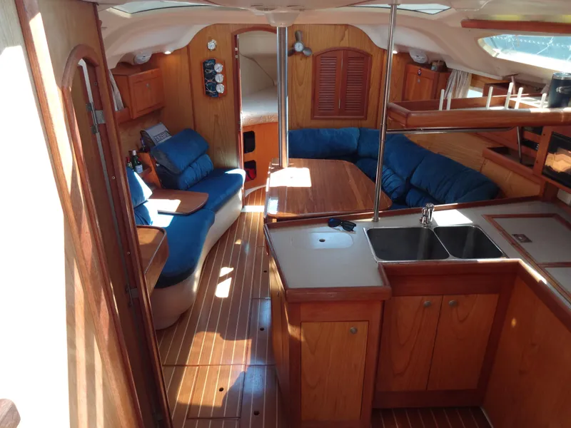Slide: The Image of Interior of a 2001 Hunter 380 sailboat with wood finish and blue seating. - 29