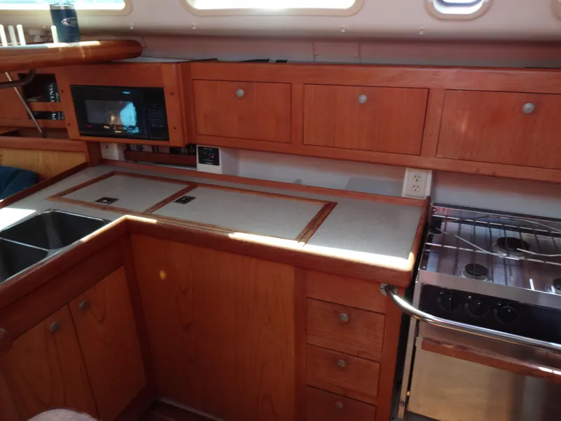 Slide: The Image of 2001 Hunter 380 yacht kitchen with wood cabinets, stove, and microwave. - 30