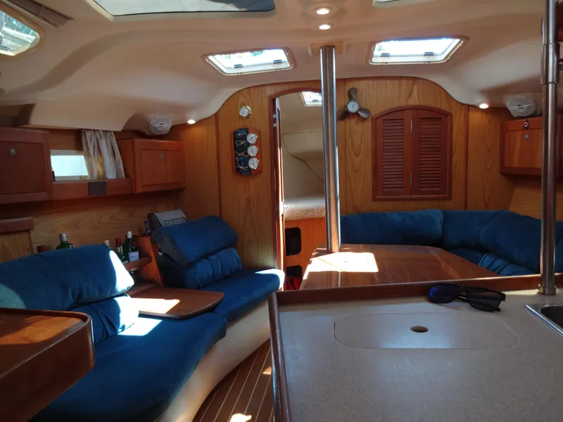Slide: The Image of Interior of 2001 Hunter 380 sailboat with blue seating and wooden accents. - 32